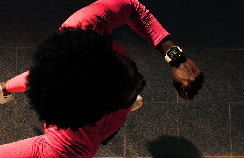 Une personne vérifiant ses progrès dans l’app Exercice d’Apple Watch Series 11 en courant