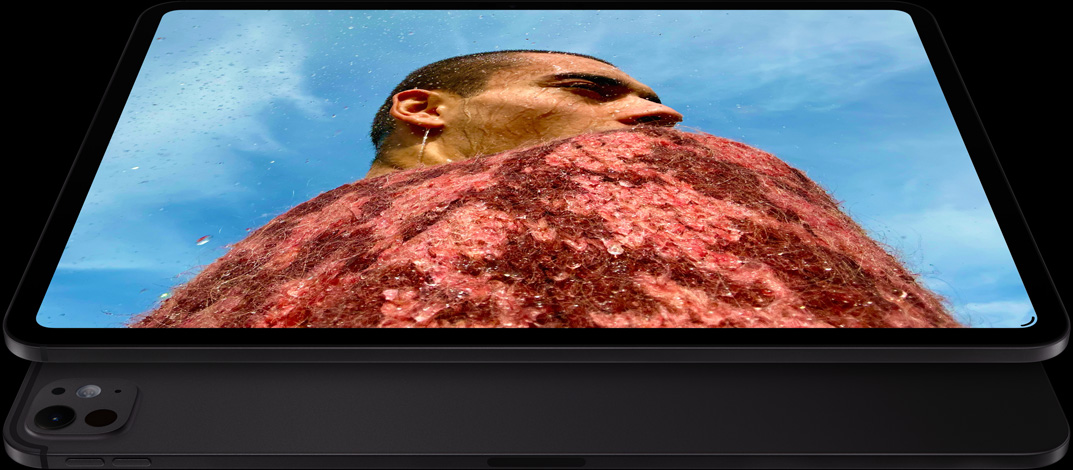iPad Pro, esikülg, horisontaalpaigutus, kosmosemust värv, ümarad nurgad, ekraani must serv, ekraanil foto mehest punases kampsunis sinise taeva all, allpool, teine iPad Pro, tagakülg, horisontaalpaigutus, kosmosemust värv, pro-kaamerasüsteem, helitugevuse tõstmise nupp, helitugevuse vähendamise nupp
